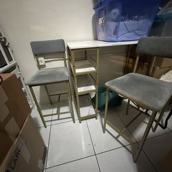 Plastic Server Table With Two Gray Chairs