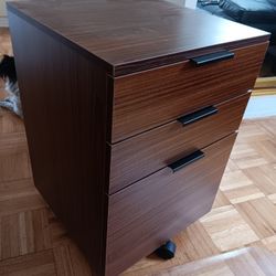 three drawers filing cabinet and black handles on wheels 