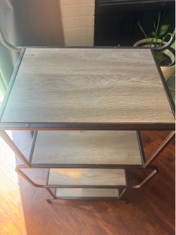 Selling this sturdy 4-tier shelf with a black metal frame and wood-look shelves.