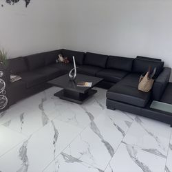 Black U shaped couch equipped w/ light table!