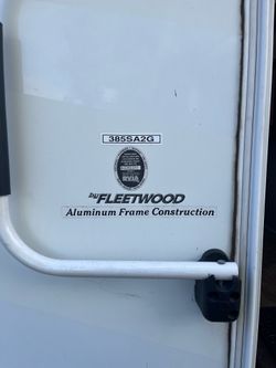 Fleetwood Formula 385SA2G fifth wheel RV. Has white exterior with aluminum frame construction. Has an awning and multiple windows. Has several exterio