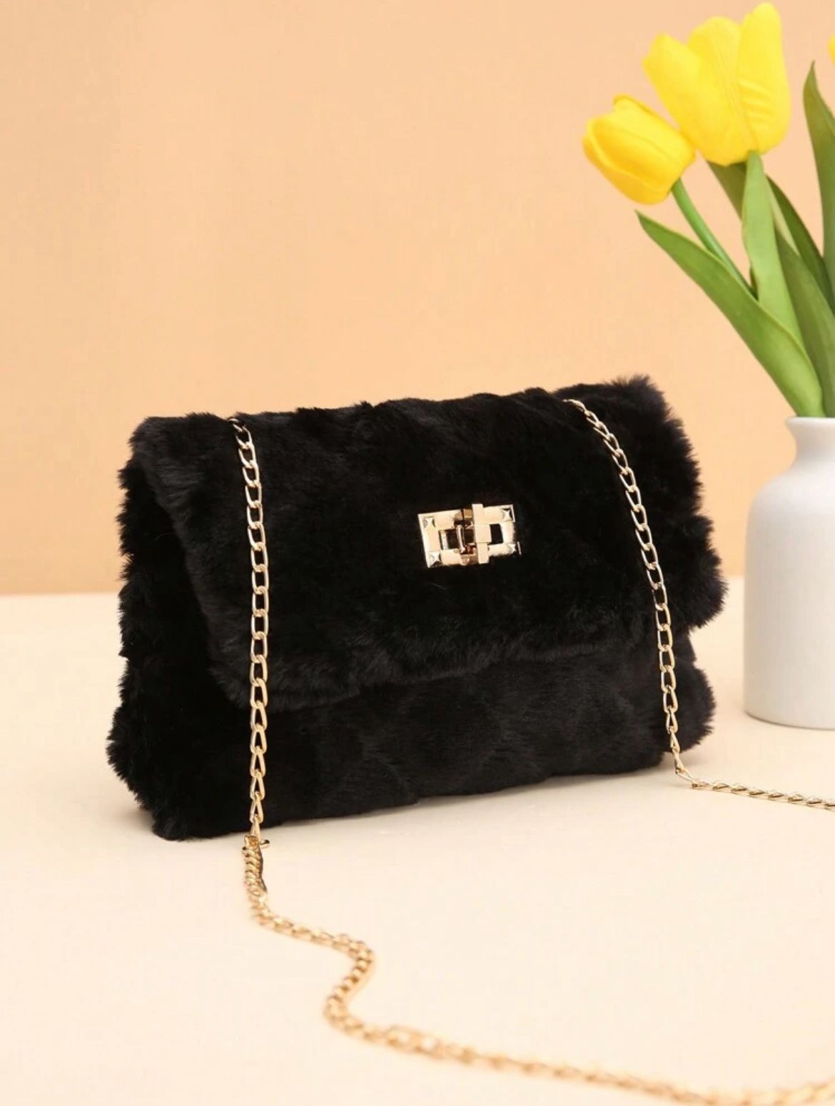 Bleach fur bag with a gold metal strap.