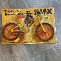vintage Huffy Mini BMX toy bike, likely from the 1980s. The packaging mentions several popular BMX brands from that era, including Huffy, Raleigh, Kuw