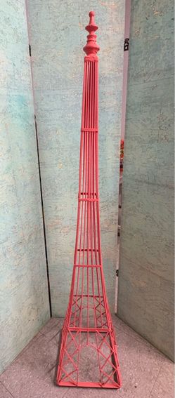 Large red metal Eiffel Tower-style decorative piece.