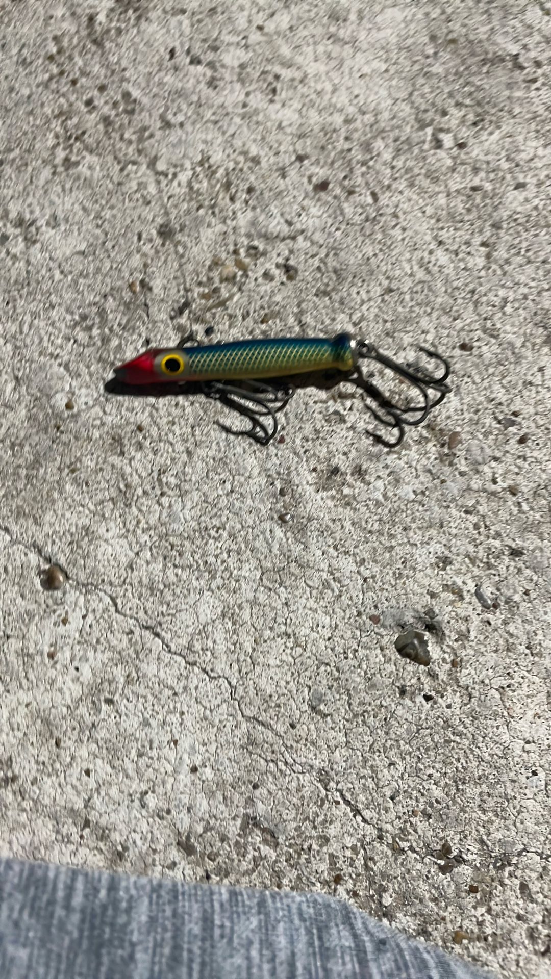 hard-bodied fishing lure, possibly a topwater or jerkbait style, designed to mimic the appearance of a small baitfish