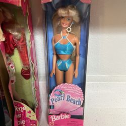 1997 Pearl Beach Barbie doll by Mattel, stock number 18576.  The doll wears a blue glittery bikini with white pearl accents.  It includes a human-size
