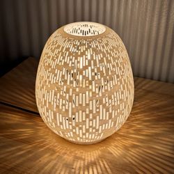 The VALERIE Lamp is a modern ambient lamp designed to transform the atmosphere of any room with its beautiful shadow-casting pattern. When lit, the ar