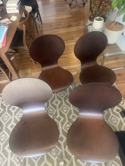 Four wood stacking chairs with chrome legs