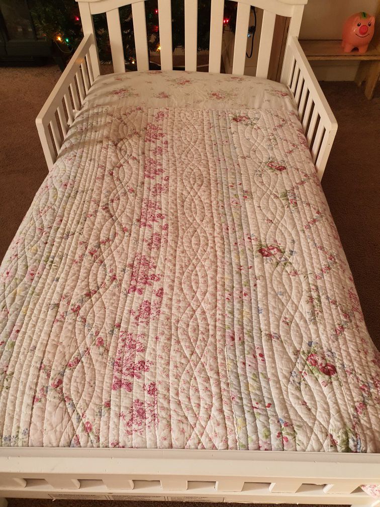 Toddler bed with matress and bedding on it