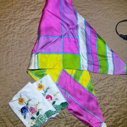 vibrant, geometric print silk scarf alongside embroidered white linens, likely classified as vintage clothing accessories and home decor
