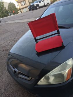 Comfortable red portable stadium seat for outdoor or indoor events.