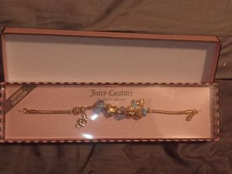 gold-tone Juicy Couture Heritage Collection charm bracelet with blue and gold charms. 
