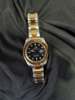 two-tone Rolex Submariner featuring a black dial and a yellow gold bezel