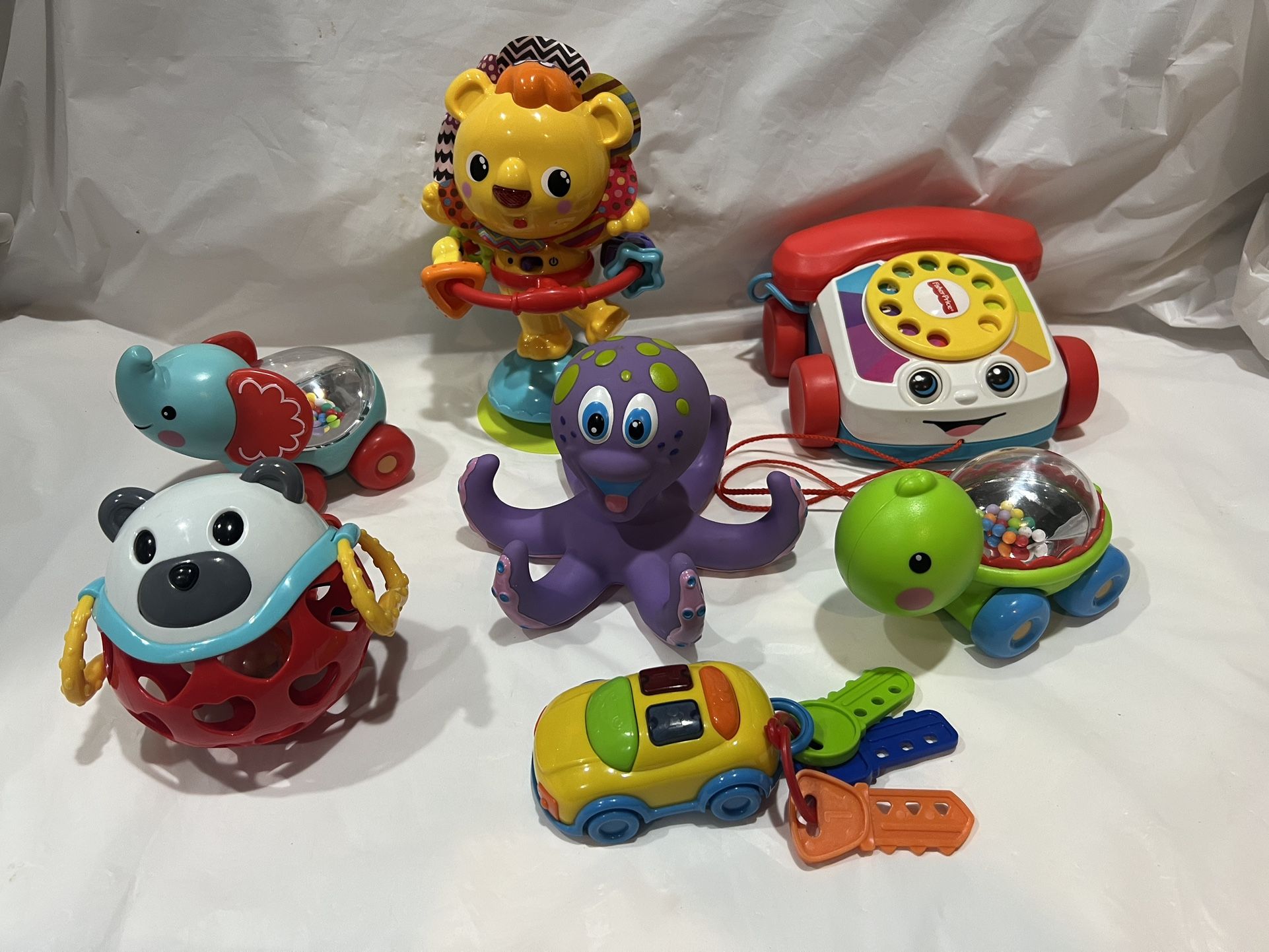 Assorted of colorful baby toys including a lion, octopus, and turtle.