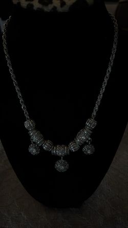 silver-toned beaded necklace featuring ornate, patterned cylindrical beads and matching spherical pendants, similar in style to traditional Yemeni or