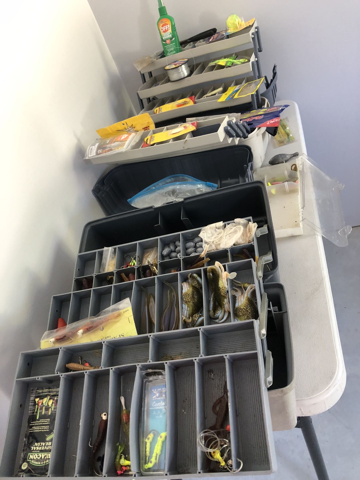 Table Full Of Fishing Lures And Weights With Tackle Boxes Tools Rain Jacket And More
