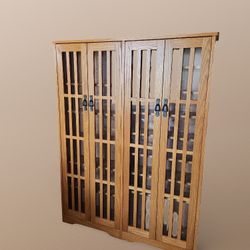 Multimedia cabinet with tempered glass doors and an oak finish. 