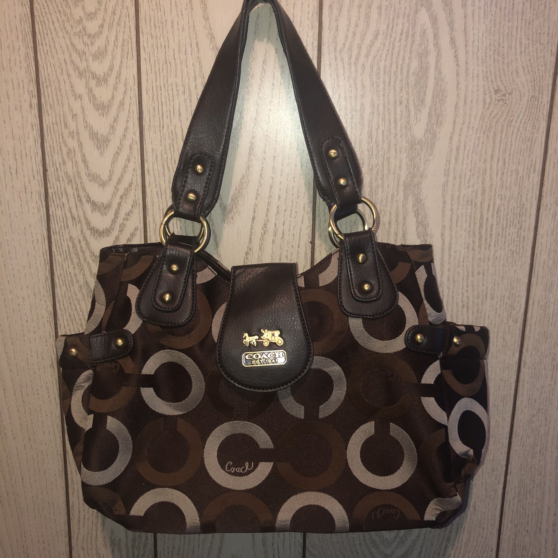 Large and beautiful brown and tan purse in near brand new condition except for a very small tear in the lining at the top inside. See all pics for de