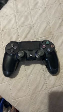 black Sony PlayStation 4 DualShock 4 Wireless Controller resting