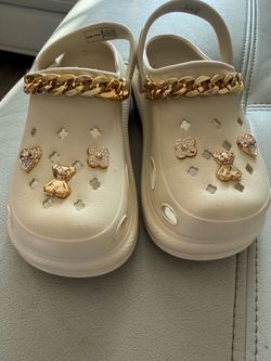 Beige crocs/clogs with gold accessories