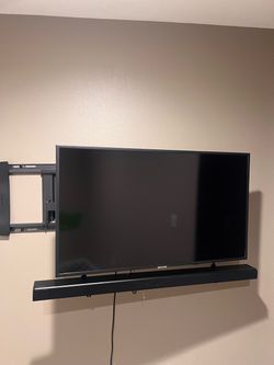 Samsung TV with a sistem and  wall hanging