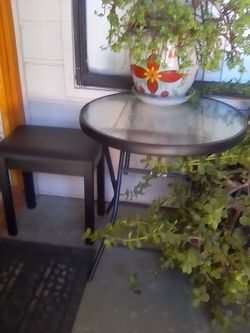 Small glass top bistro table with one bench style chair