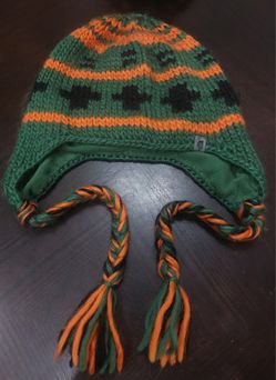 The North Face" Vintage knitted earflap hat has green, orange, and black colors