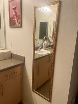 Gold colored ornate full length mirror