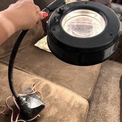 Antique magnifying glass that can attach to workbench or desk