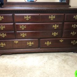 With large dresser with a mirror, dark wood