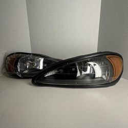 Headlights For 1999 To 2005 Pontiac Grand AM; Black Housing With Amber Corners. / Luces Negras 