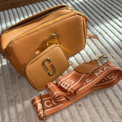 Stylish Tan Crossbody Camera Bag with Gold Accents and Logo Strap