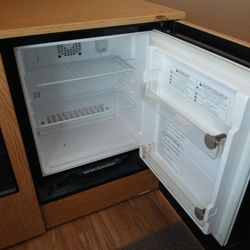 small refrigerator in a nice cabinet