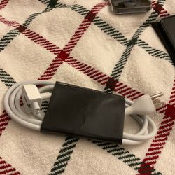 Apple laptop power adapter (MacBook charger) with the cable wrapped around it. 2.5 A, 125V Used to charge MacBook laptops The small magnetic connector