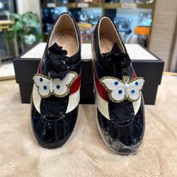 Gucci black patent leather runway shoes with red, white, and blue stripes
