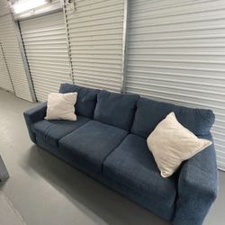 Blue couch with Ugg Pillows