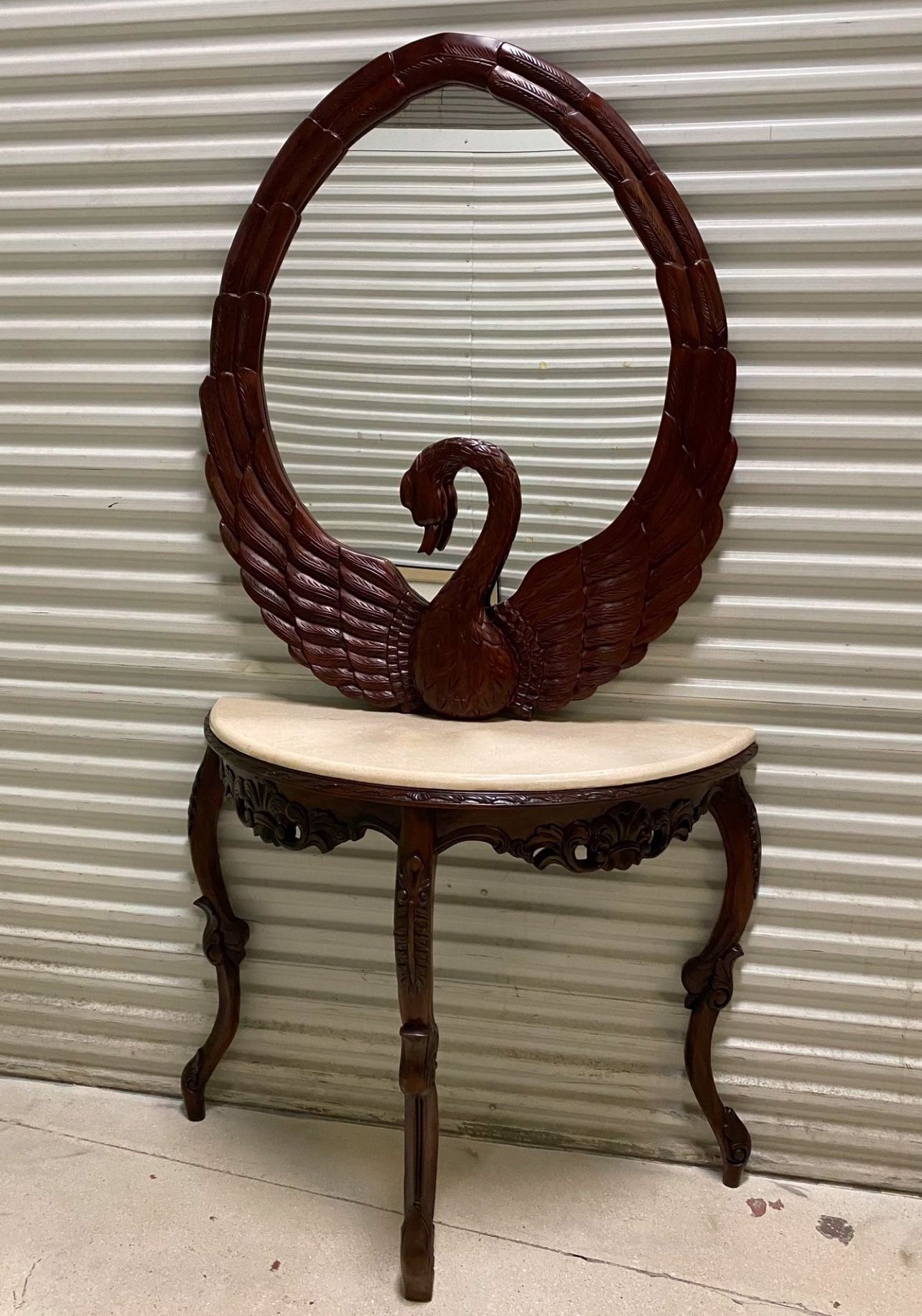 Hand carved Swan wall mirror features sculptural swan carving and a deep, matching table W marble top
