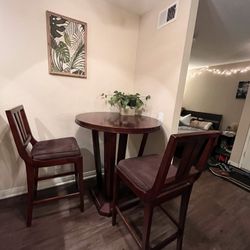 Round Wooden High Top Table And Two Chairs