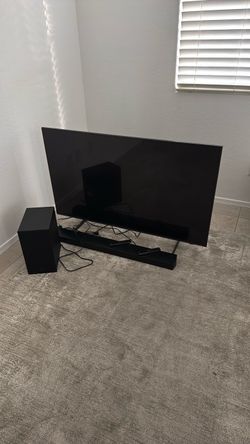 Large Flat Screen TV with Soundbar and Subwoofer