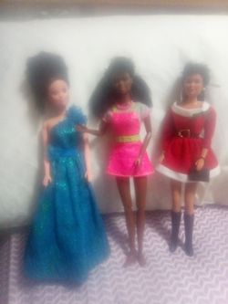 Three Barbies clothes and case