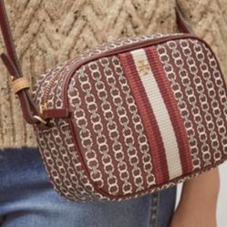Beautiful Tory Burch crossbody bag featuring a classic woven logo pattern and striped detail. Chic, compact, and perfect for everyday wear.