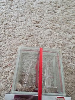 Silver sailboats in a closed glass container.