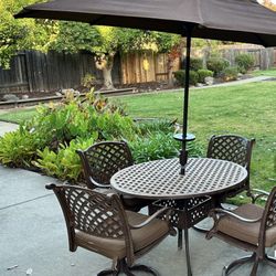 patio furniture set includes - 48" Table, 4 swivel chairs with cushions, 8' Treasure Garden umbrella that tilts - matching sunbrella material for cush