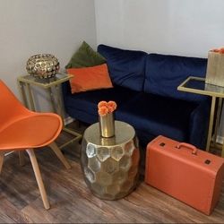 Blue Velvet Loveseat, Orange Chair, Gold Side Tables