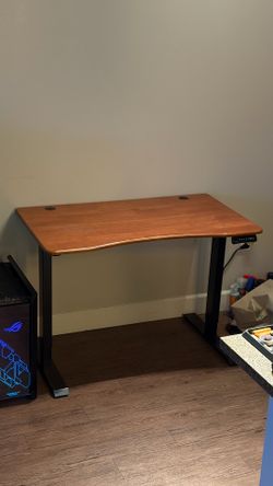 Desk with adjustable height (motorized), for sitting or standing.