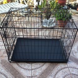 Strong metal cage for transporting animals, foldable with its tray, clean like new, measures 30 inches long, 19 inches wide and 21 inches high
