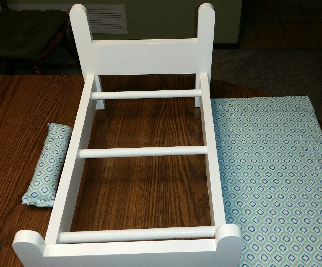 Handcrafted wooden doll bed with matching mattress and pillow.