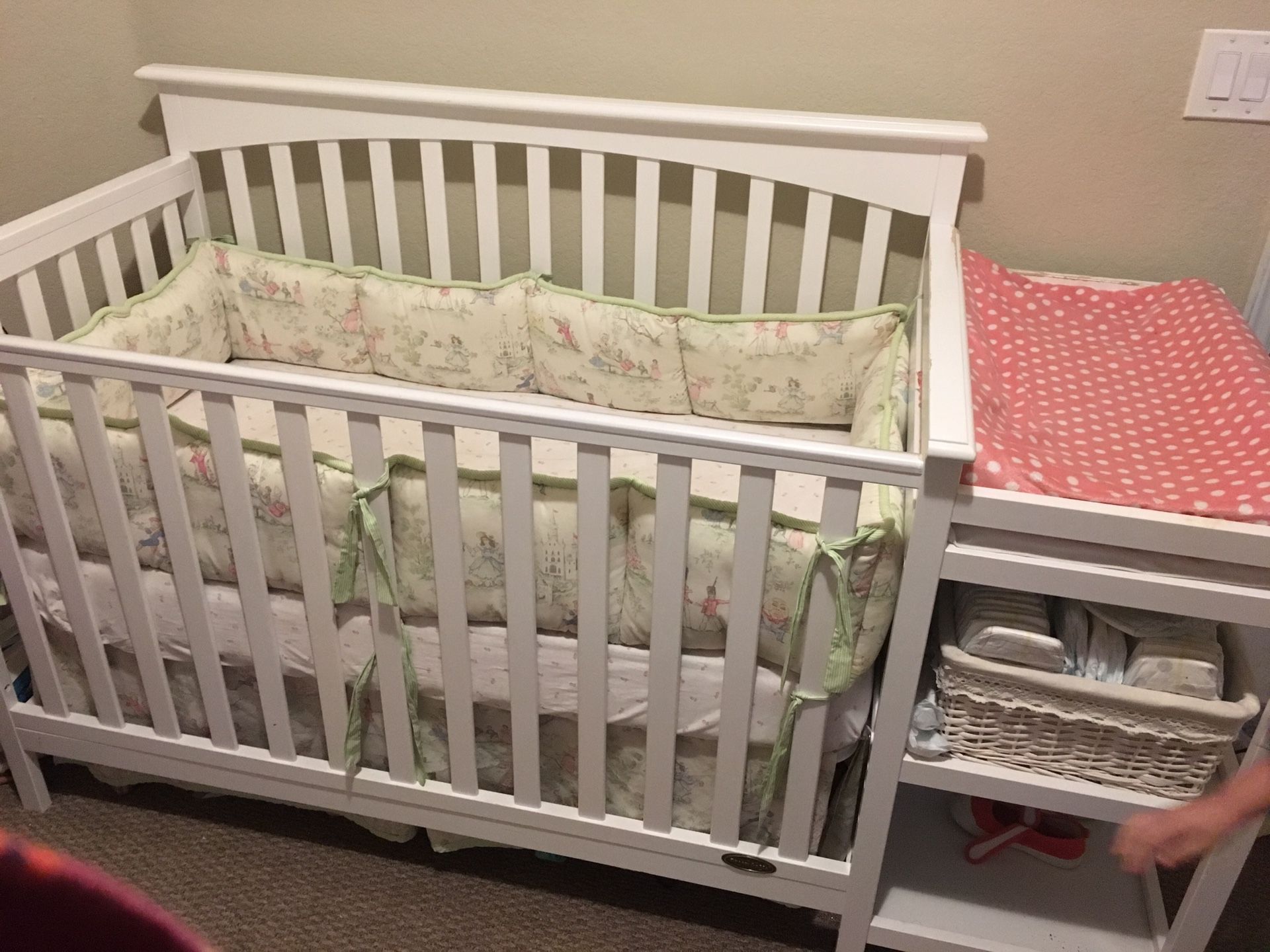 White crib with changing table attached.
