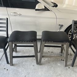 Two Black Chairs With One Black Stool