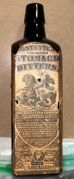 amber glass bottle of Dr. J. Hostetter's Celebrated Stomach Bitters featuring its original paper label